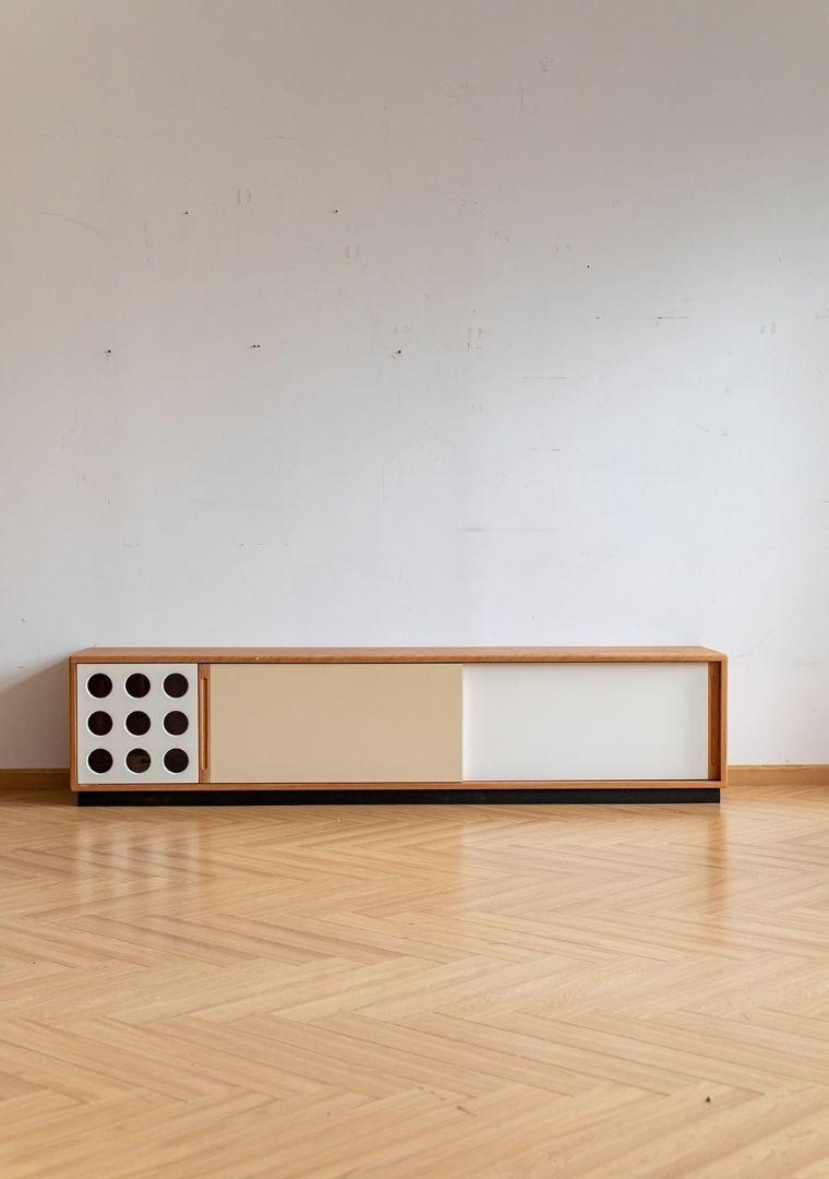 Modern wooden console table with decorative elements on a light wood floor.