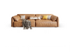 Modern tan leather sofa with assorted cushions and a houndstooth throw blanket