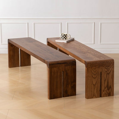 Two wooden benches in a room with a light-colored floor and white walls.
