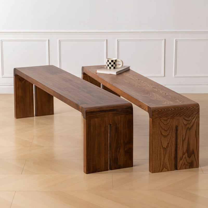 Two wooden benches in a room with a light-colored floor and white walls.