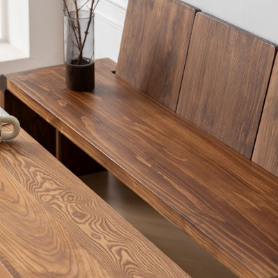 Wooden bench with a vase of branches on a windowsill