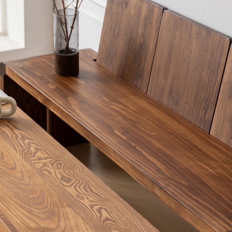 Wooden bench with a vase of branches on a windowsill