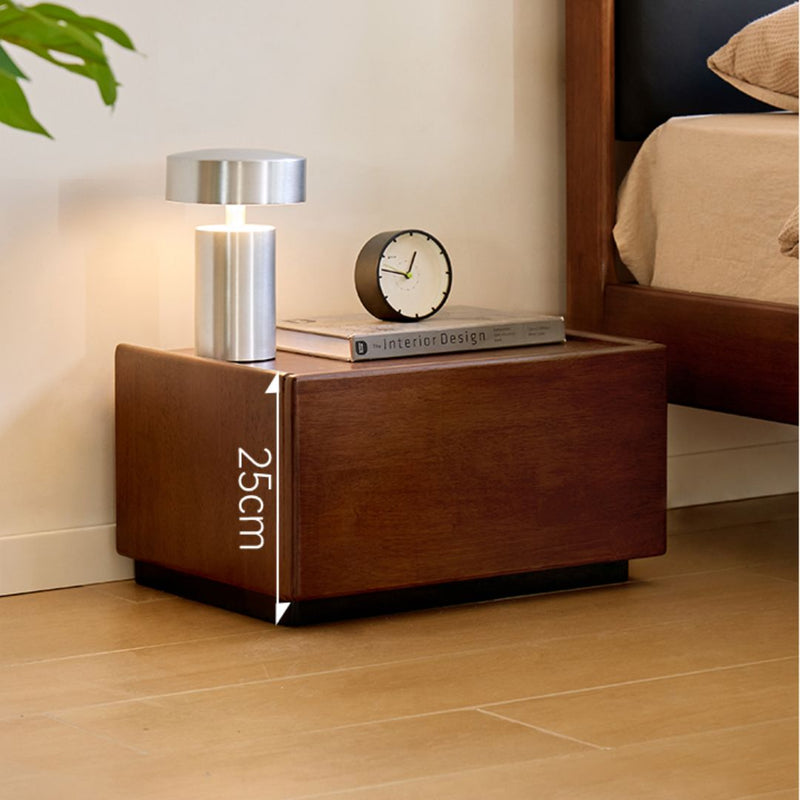 Wooden nightstand with lamp and clock in a bedroom setting